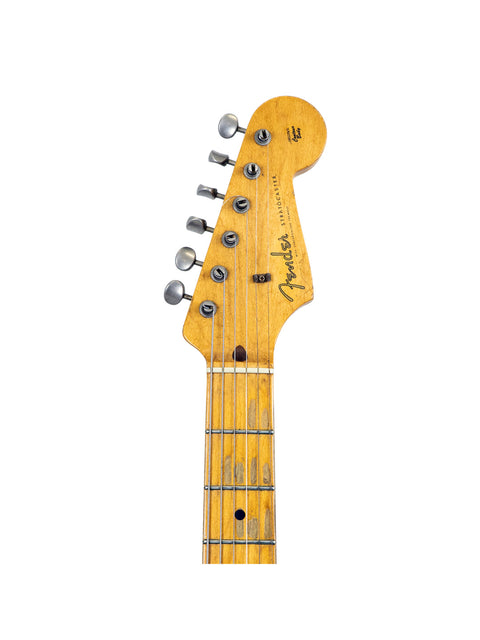 The Fender Custom Shop Time Machine 58 Strat Relic guitar stands out against a white backdrop, highlighting its classic features.