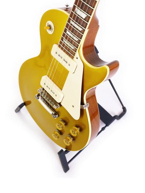 The Gibson Les Paul Standard Gold gleams with its classic gold top, a 2014 Custom Historic VOS reissue from 1956.