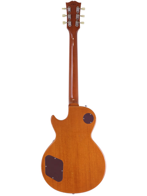 The Gibson Les Paul electric guitar in natural wood finish, highlighting its vintage appeal and custom upgrades from 2006.