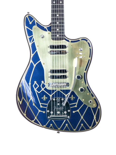 The Zachary & Mercer Mastermind “Royal” Offset guitar boasts a stunning blue and gold finish with a chic gold and black pattern.