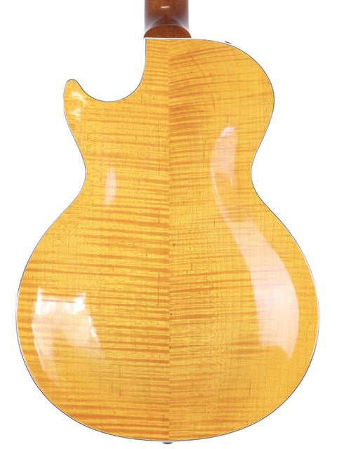 The back of a 2003 Gibson Les Paul Supreme acoustic guitar, featuring a vibrant yellow finish and smooth contours.
