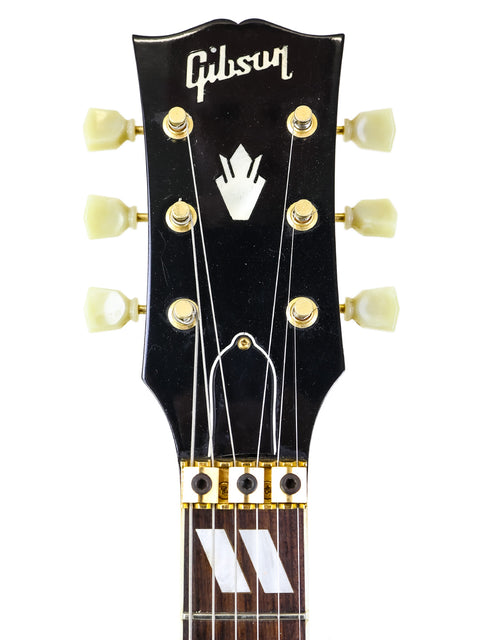 The image features a Gibson Les Paul Custom Shop guitar, highlighting its elegant features next to a 1997 USA Gibson Nighthawk.
