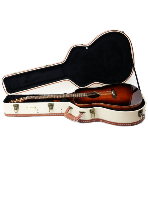 The image features a brown guitar case with an Alvarez MDA66SHB guitar, highlighting its classic style and craftsmanship.