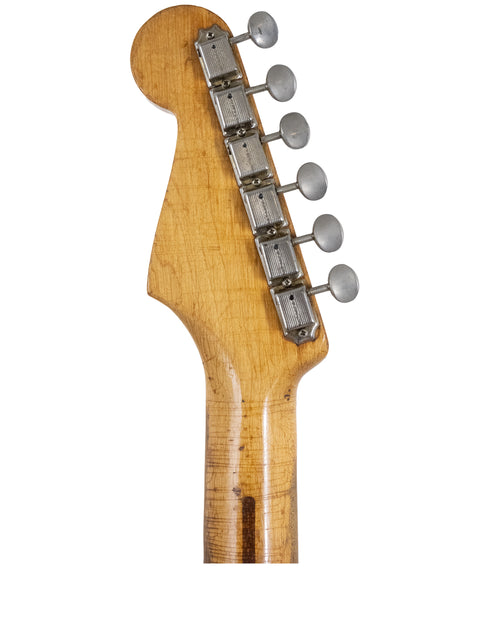 The neck of a 1958 Fender Stratocaster guitar, emphasizing its iconic shape and vintage appeal.