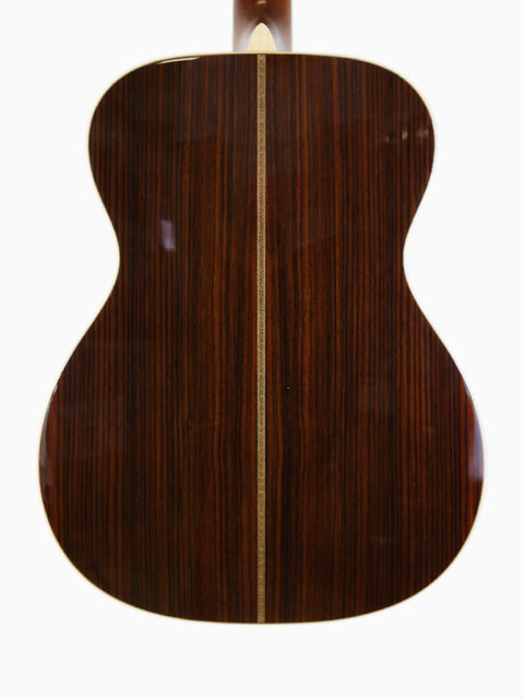 The wooden back of a Martin 000-28 Modern Deluxe acoustic guitar, highlighting its craftsmanship from USA 2022.