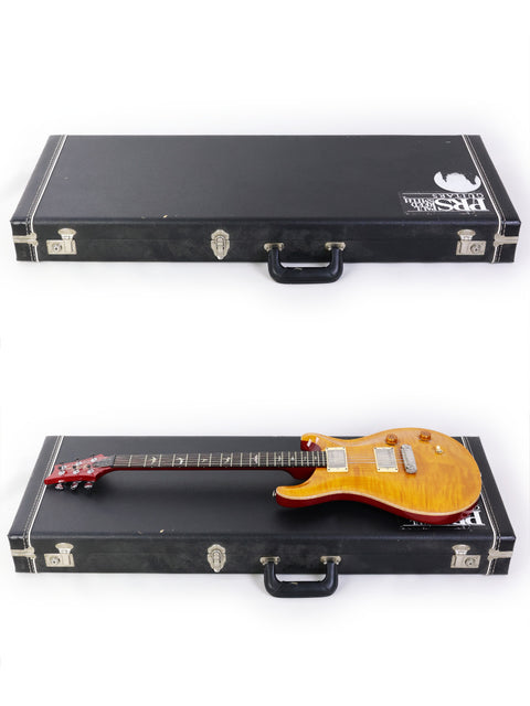 Two guitars, including a 2005 PRS Custom 22, are displayed in a case on a clean white background.