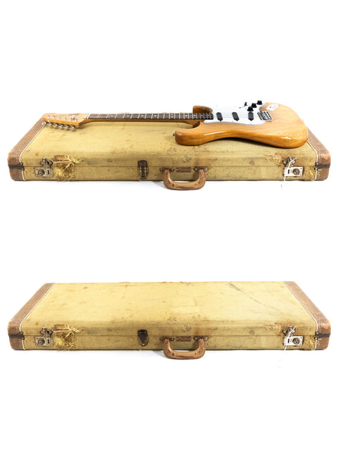 Two weathered suitcases showcasing a vintage 1979 Fender Stratocaster guitar inside.
