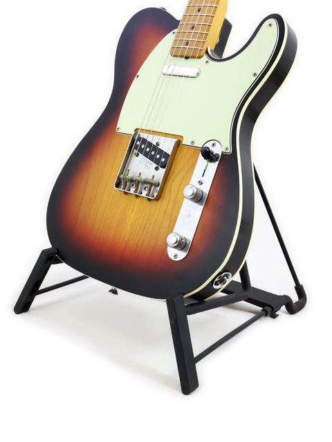 Txxx Custom Style Partscaster guitar in matte sunburst finish, showcased on a stand with a striking black background.