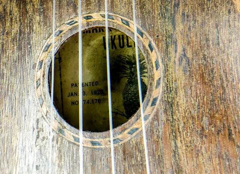 Vintage 1930 Kamaka Pineapple Ukulele with a label on the back, capturing the essence of Hawaiian musical heritage.