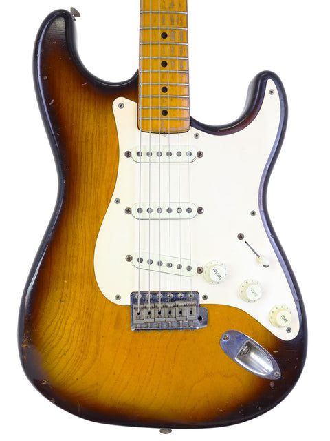 Vintage 1954 Fender Custom Shop Stratocaster in sunburst finish, displayed with its original case.
