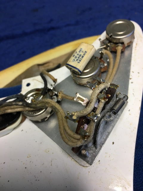 Vintage 1959 Fender Stratocaster guitar, blond finish and maple neck, with wires, representing iconic American musical heritage.
