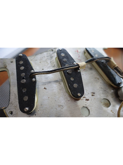 Vintage 1963 L Series Stratocaster guitar neck close-up, focusing on screws and classic design details.