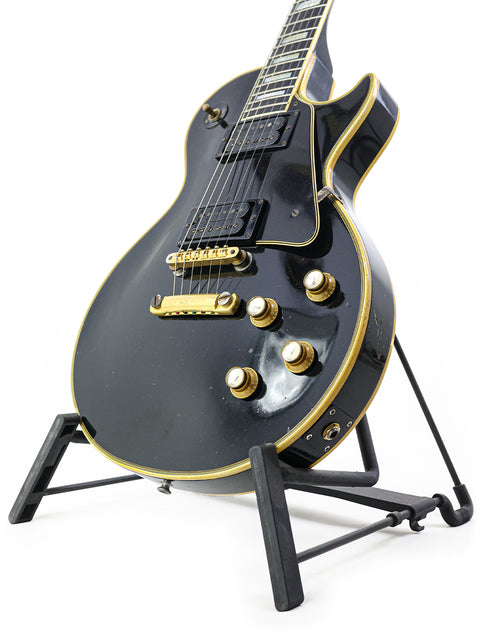 Vintage 1969 Gibson Les Paul Custom, black electric guitar on a stand with striking gold hardware.