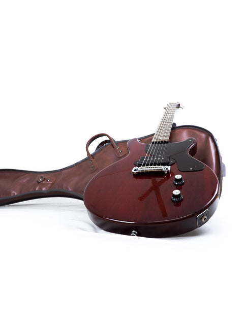 Vintage 1980s Burny Les Paul Jr guitar in red with a matching case, displayed against a stark white backdrop.