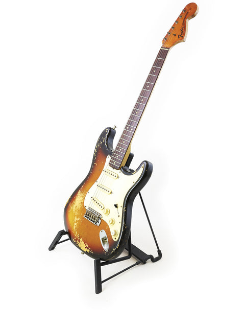 Vintage Fender Stratocaster from 1970 on a stand, beautifully contrasted against a bright white background.