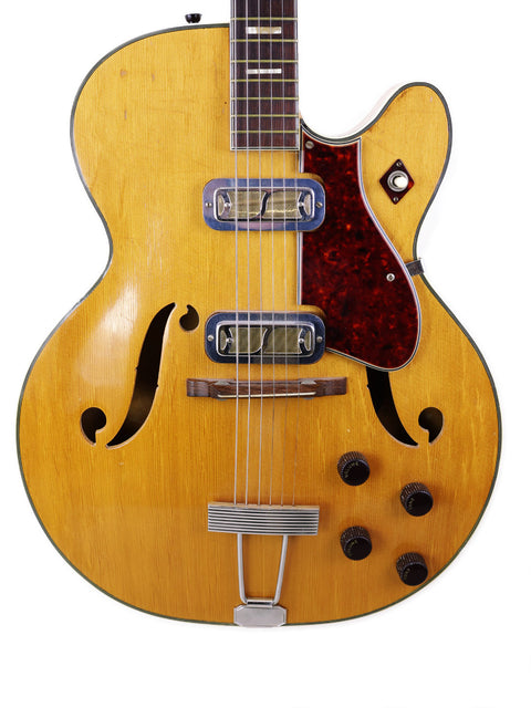  Vintage Harmony H71 Meteor guitar with a wooden body and sleek black pickguard, perfect for collectors and musicians alike.