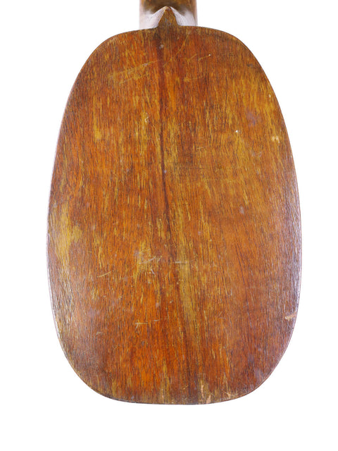 Wooden paddle with a handle, reflecting the vintage style of a 1930 Kamaka Pineapple Ukulele from Hawaii.