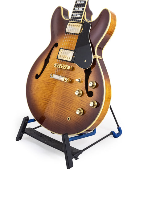 Yamaha SA 2200 Thinline guitar elegantly positioned on a stand, surrounded by a bright white background.