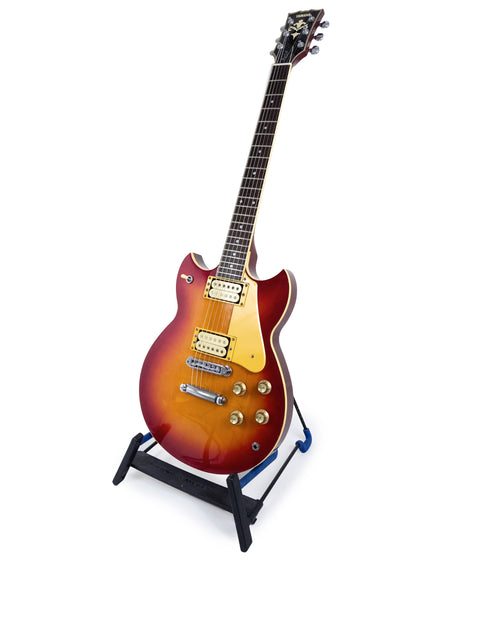 Yamaha SG 800S guitar displayed on a stand, featuring a sleek design with a white backdrop, highlighting its 1981 vintage charm.