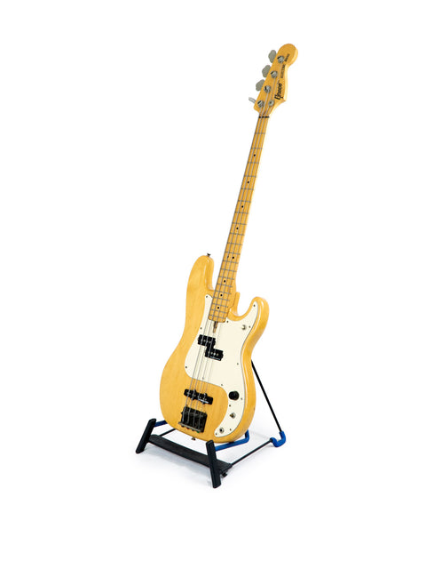 Yellow electric bass guitar, Greco PB 750 model from Japan (1971-75), resting on a stand.