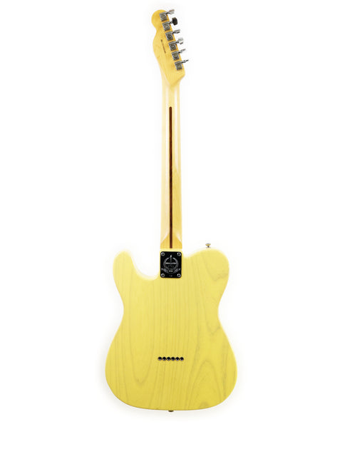 Yellow electric guitar standing vertically against a white background.