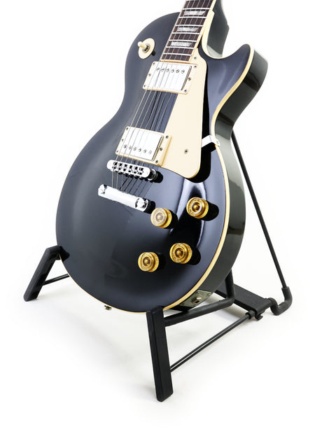 black Gibson Les Paul Standard electric guitar from 1995 displayed on a stand, showcasing its sleek design and craftsmanship.