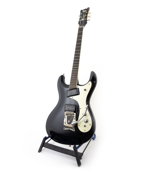 sleek black guitar, the Mosrite Ventures Model from the 1990s, elegantly positioned on a stand with a white background.