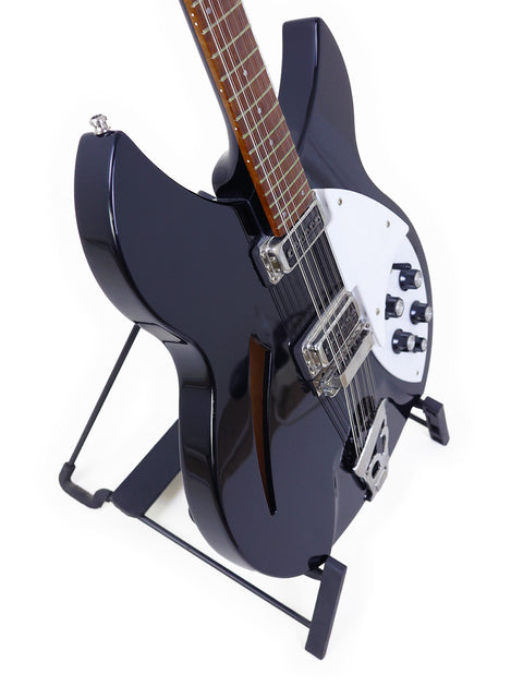 striking black electric guitar, the Rickenbacker 330 12-string from 2020, resting on a stand, ready for performance.