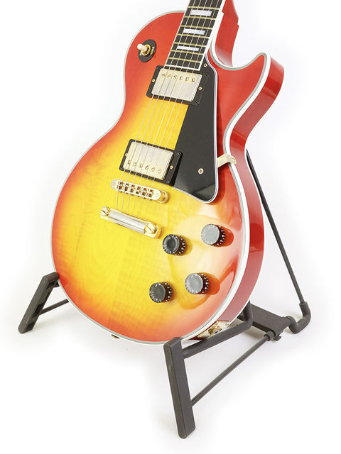 striking red and yellow Gibson Les Paul Custom guitar resting on a stand, showcasing its craftsmanship.
