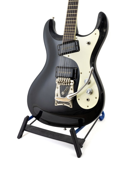 vintage black Mosrite guitar on a stand, set against a white background, representing the 1990s Ventures Model.