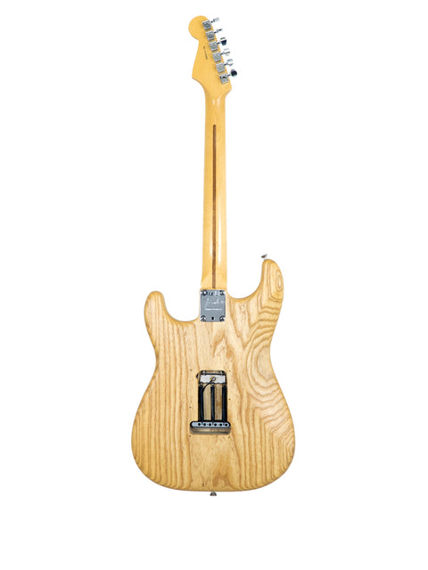 wooden-bodied Fender Stratocaster guitar, featuring a natural oiled ash finish, highlighting its craftsmanship and beauty.
