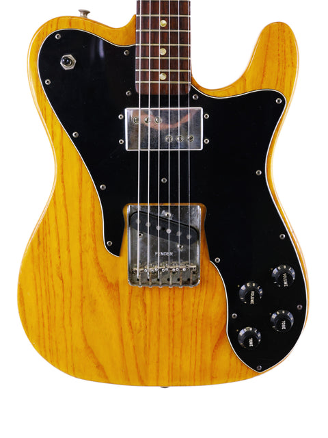 yellow Fender Telecaster Custom guitar with striking black and white stripes, showcasing its vintage 1977 design.
