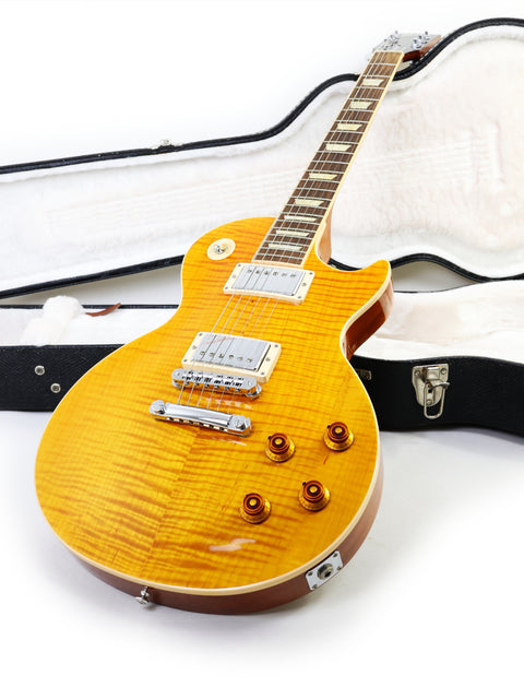 yellow Gibson Les Paul Standard electric guitar (2013) positioned next to its sturdy case, highlighting its striking color.